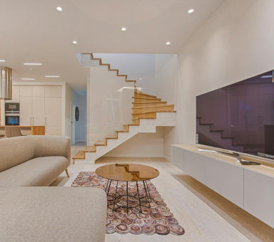 Salon moderne rénové avec escalier design en bois, éclairage encastré et aménagement intérieur contemporain